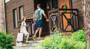 Voyageurs rentrant dans une maison de location dont le propriétaire sait tout sur la réglementation AirBnb en 2026